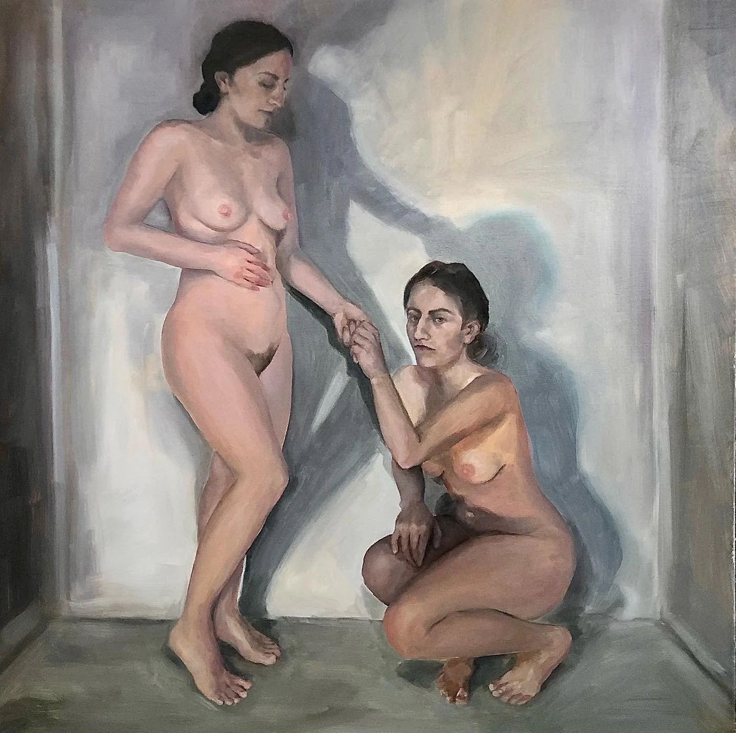 A painting of two nude women in an interior space, one standing and one kneeling, holding hands and looking at each other.