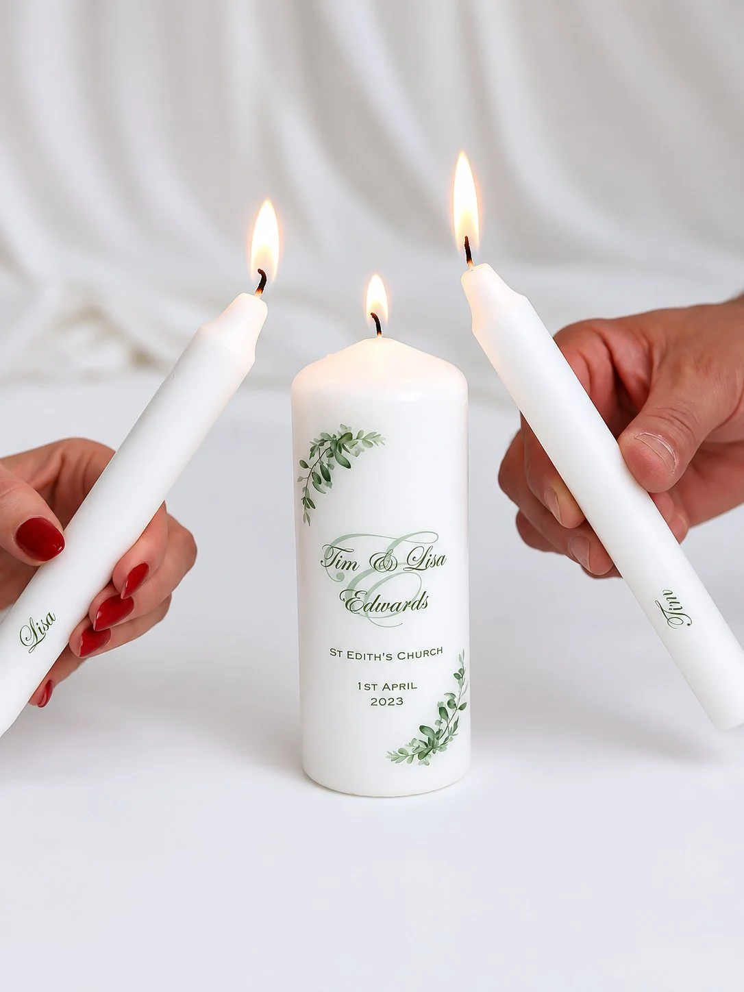 A wedding candle with the names Tim and Lisa Edwards, date April 1, 2023, and a plant design, with two people lighting taper candles in a ceremony.