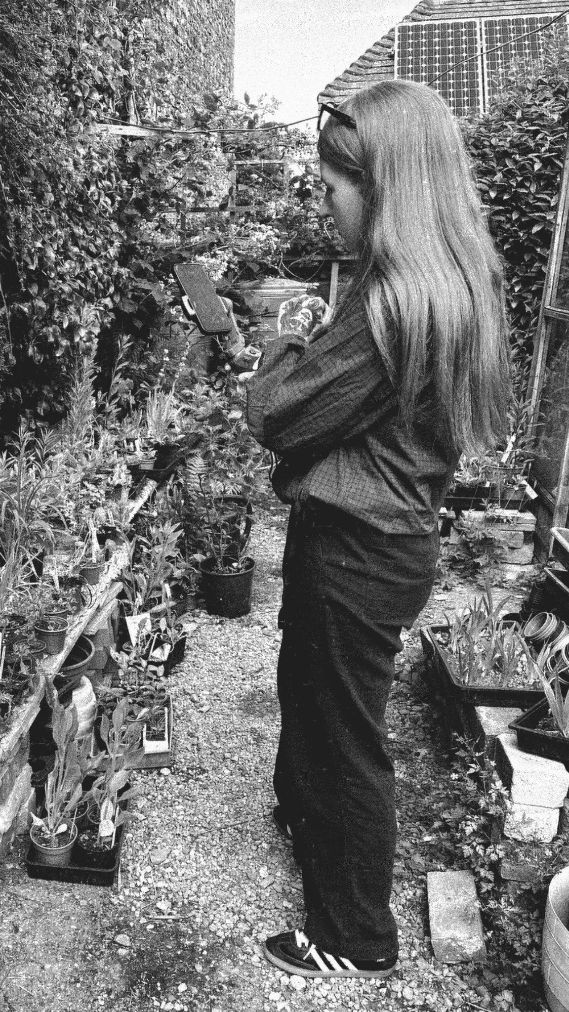 Georgie from Sunday Hill Social filming in a garden with a phone and gimbal.