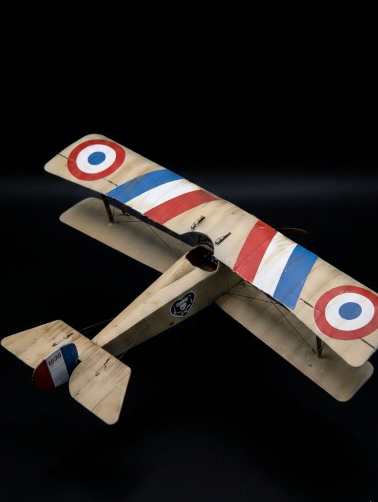 A model airplane with vintage World War I style french painted markings, displayed against a black background.