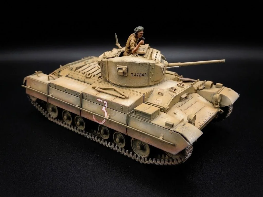 Scale model of a military tank with a figure of a soldier inside, on a black background.