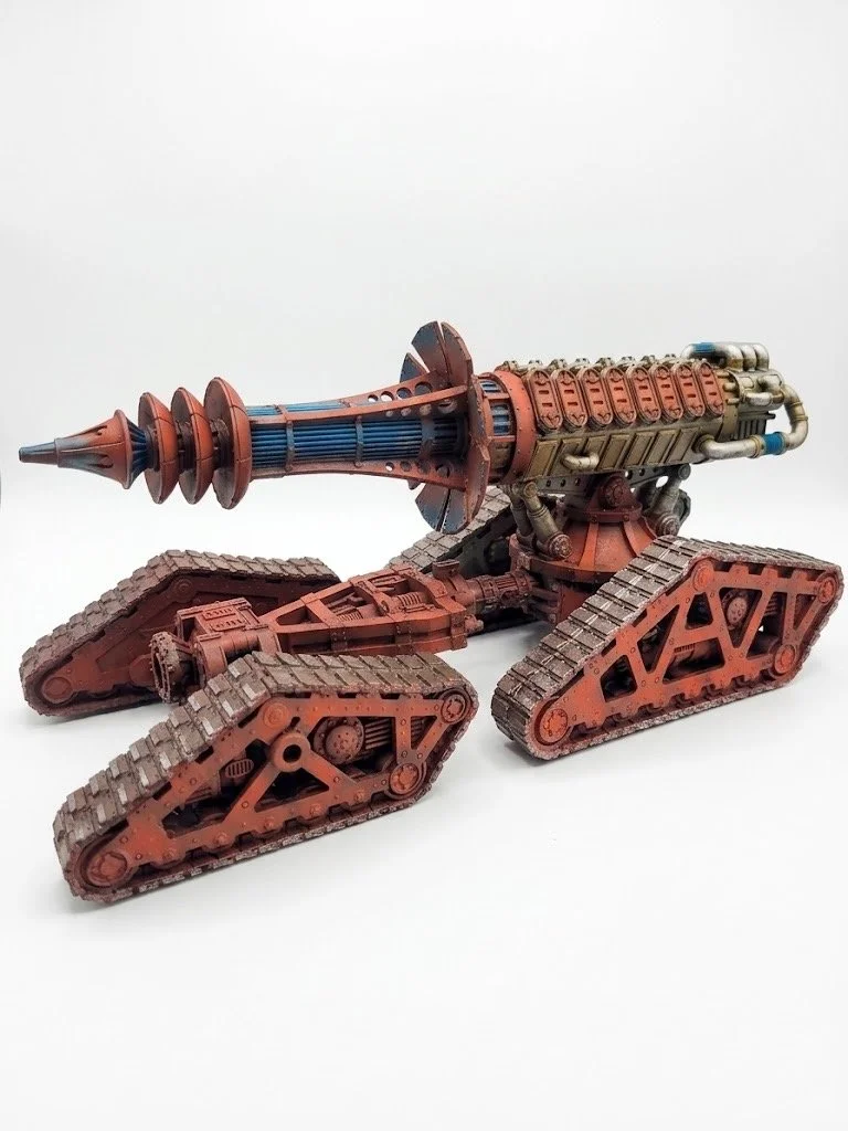 Model of a tank with a large cannon, tracked wheels, and detailed mechanical parts, painted in shades of brown and blue.