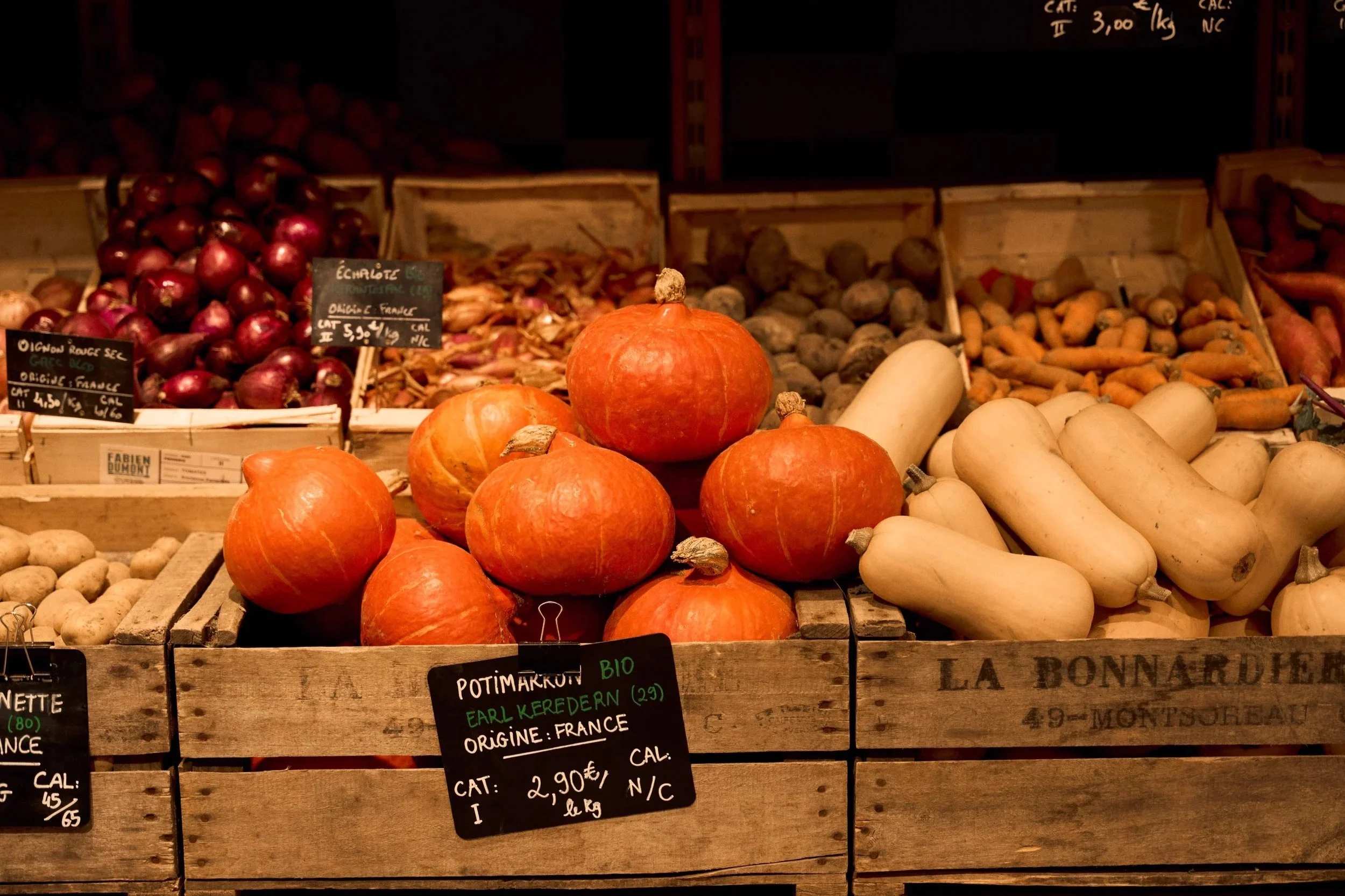 Seasonal pumpkins, squash, onions, and carrots displayed at a Paris produce market