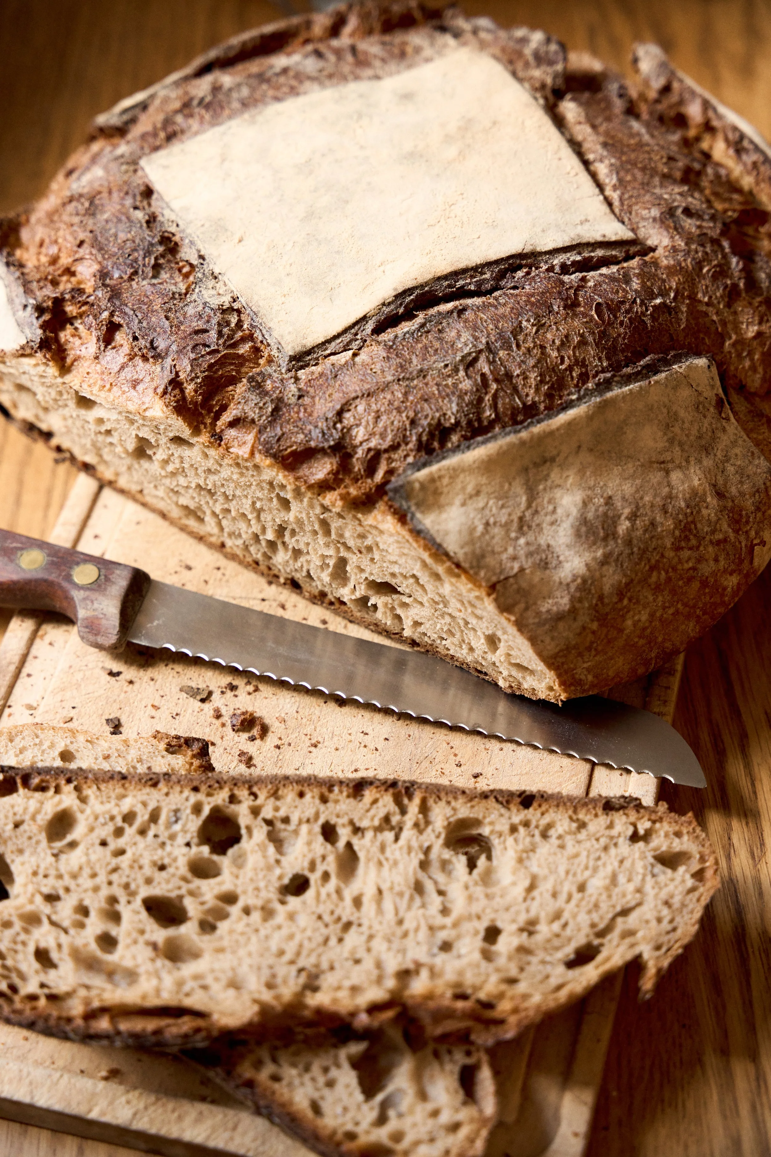 Sliced artisan sourdough bread beside a bread knife