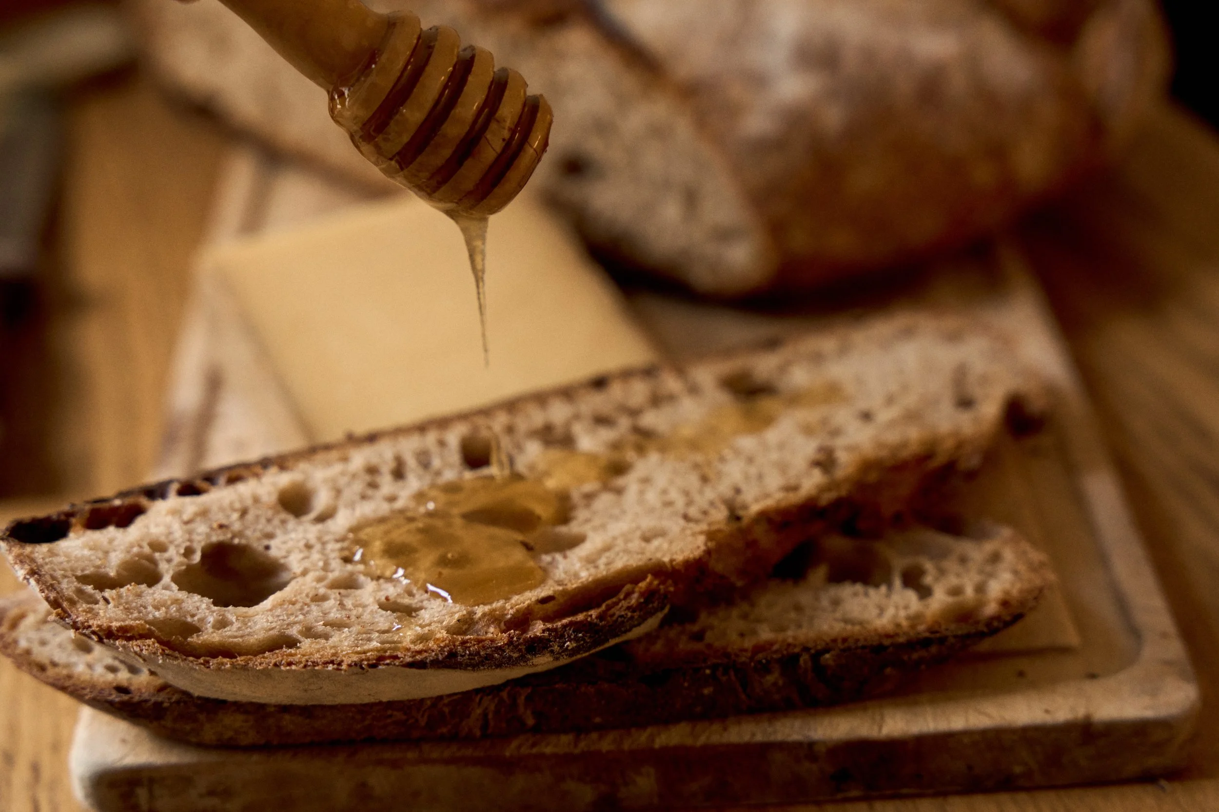 Honey drizzled over a slice of rustic French bread