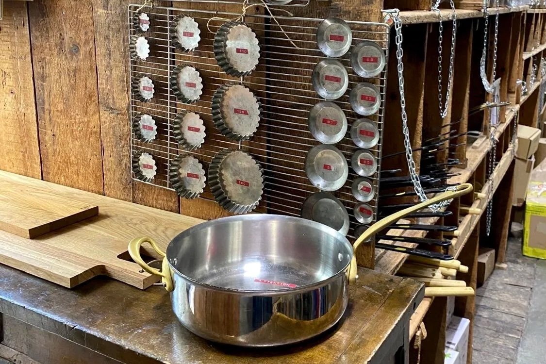 Vintage pans and pastry molds displayed at E. Dehillerin, a historic Paris cookware shop.
