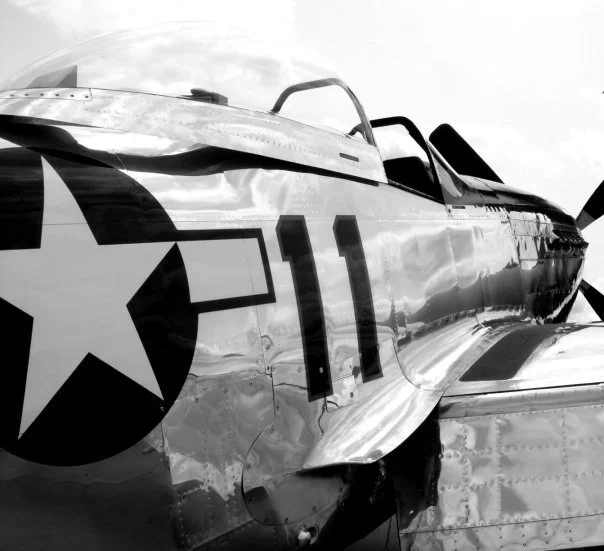 Close-up of a vintage fighter jet with military markings and the number 11, in black and white.