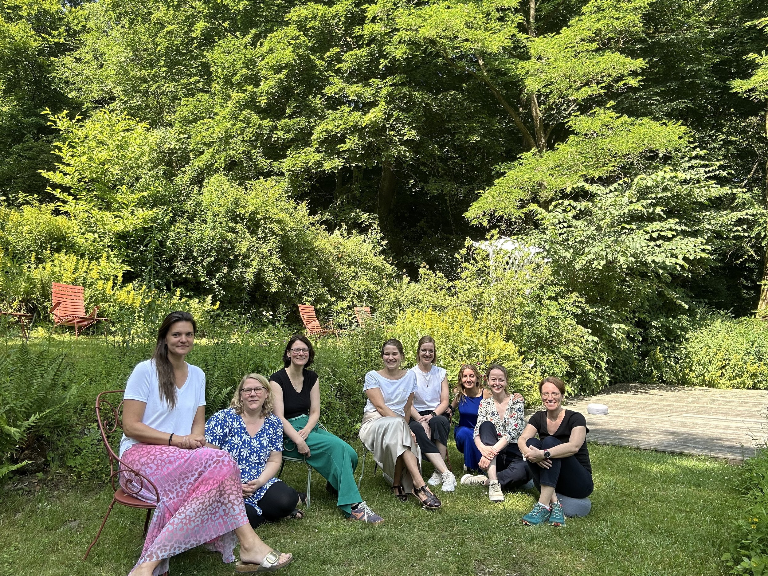 A group of professional women sitting outdoors at an emotional intelligence retreat