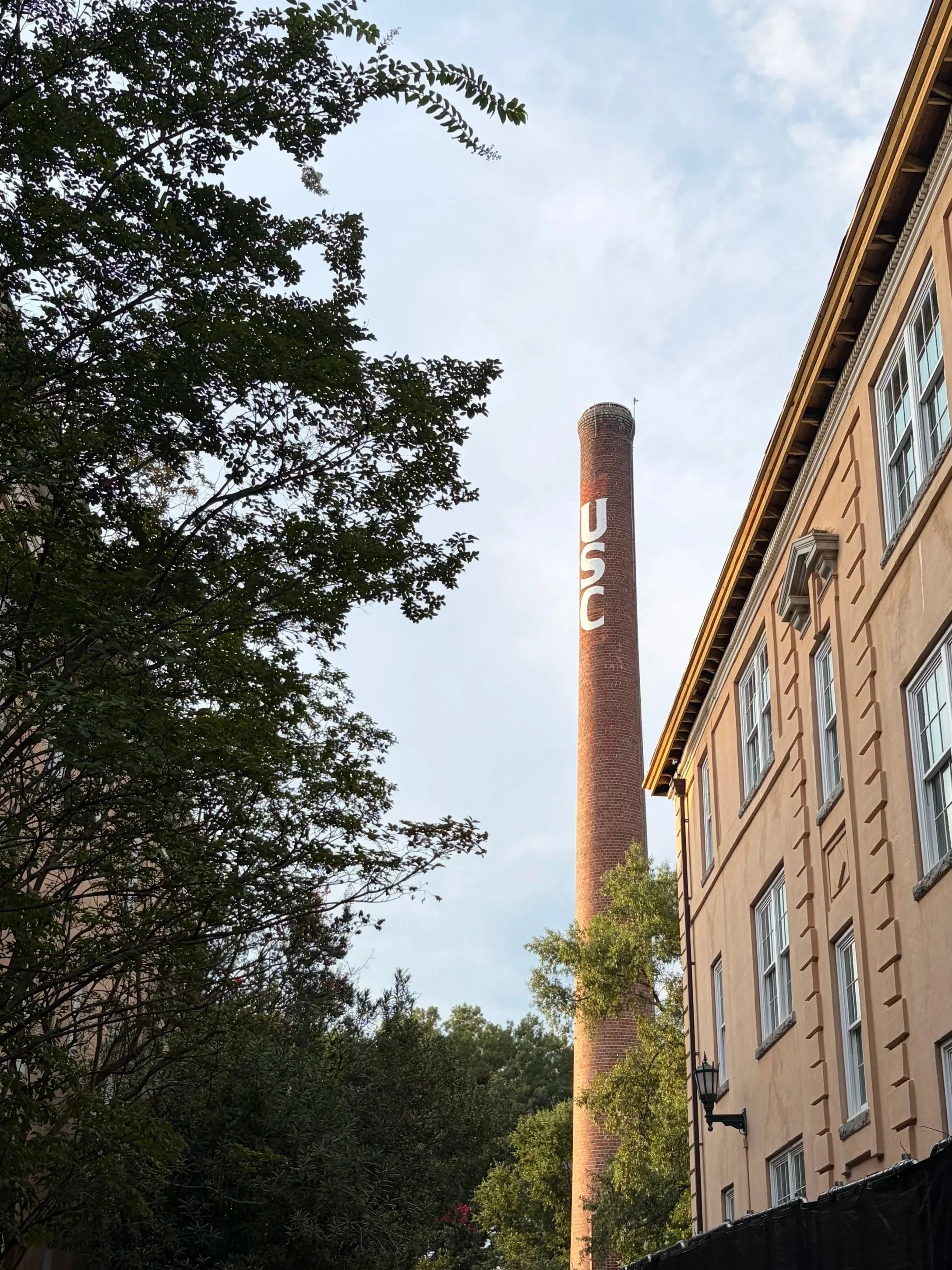 The image shows a view looking up at a smokestack with a