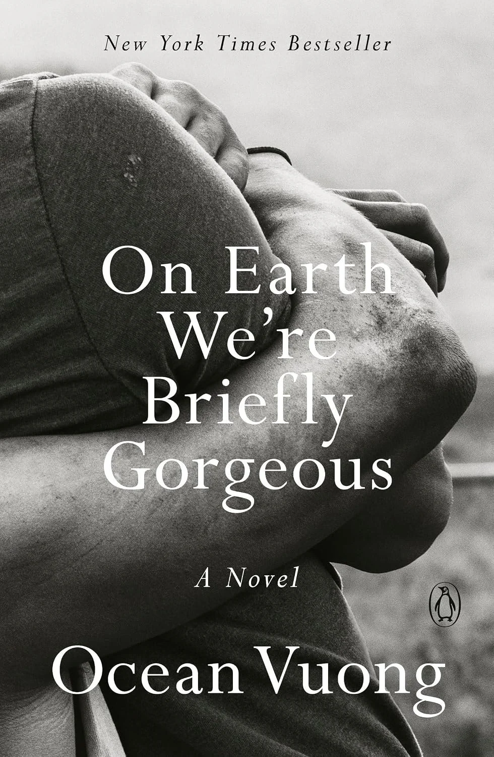Black and white cover of a book titled 'On Earth We're Briefly Gorgeous' by Ocean Vuong, featuring a close-up of a person with their arms crossed.