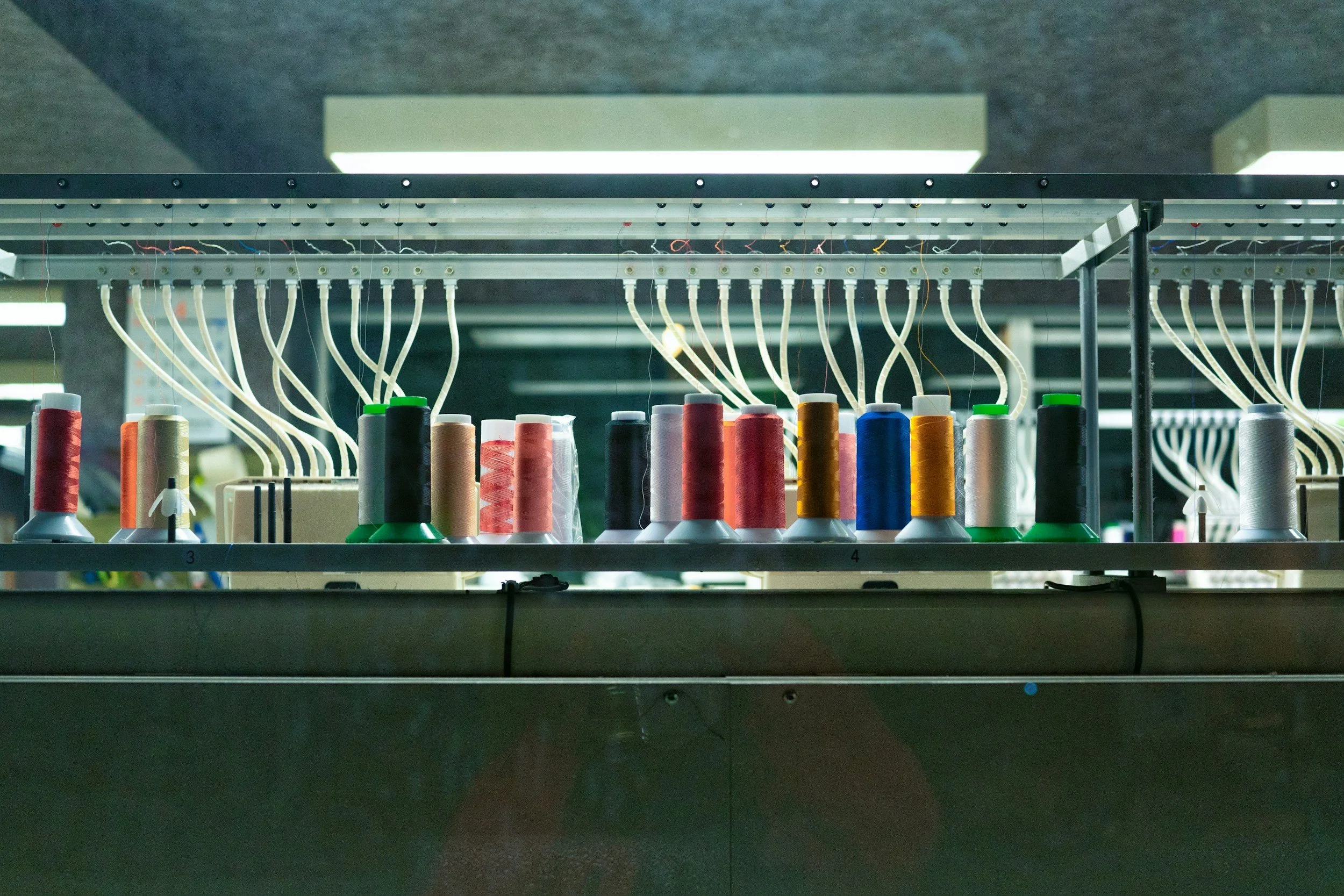 Spool threads on a sewing machine in a textile factory.