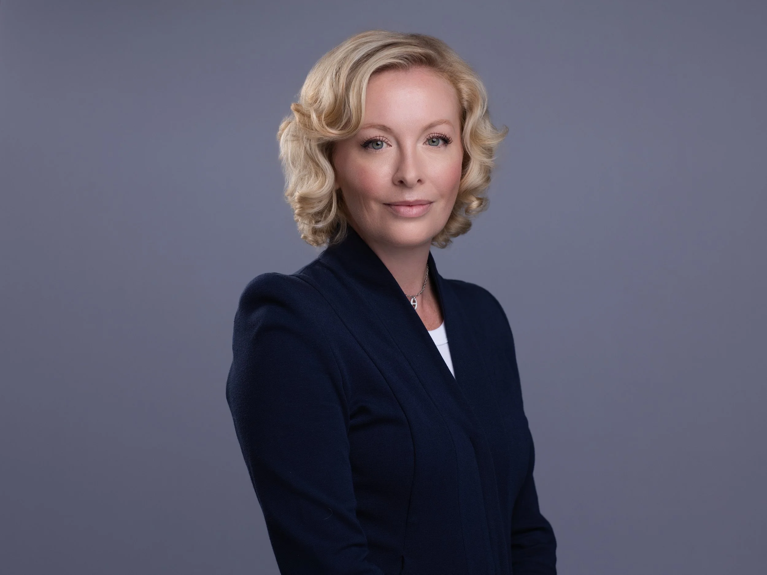 Natasha French with her arms crossed in dark blazer.