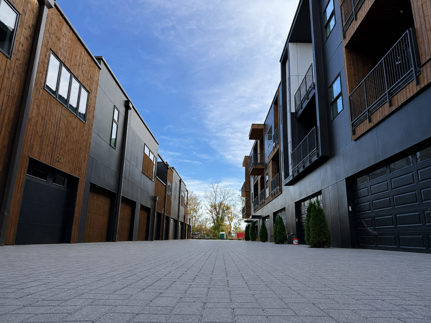 Street-level view of permeable paver drive aisle between modern townhome buildings at The Haven, completed by 4G Paving