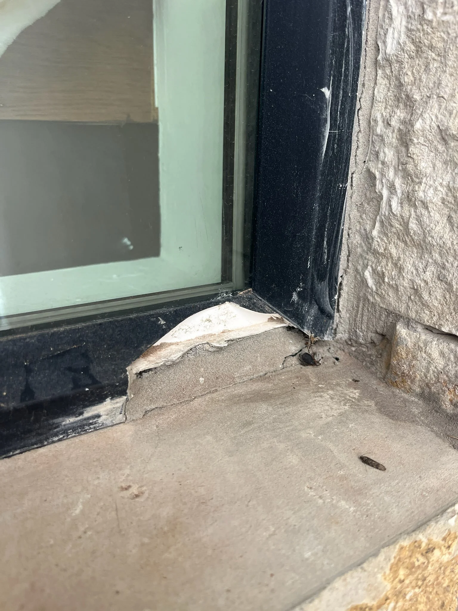 Close-up of a black broken vinyl window sill.