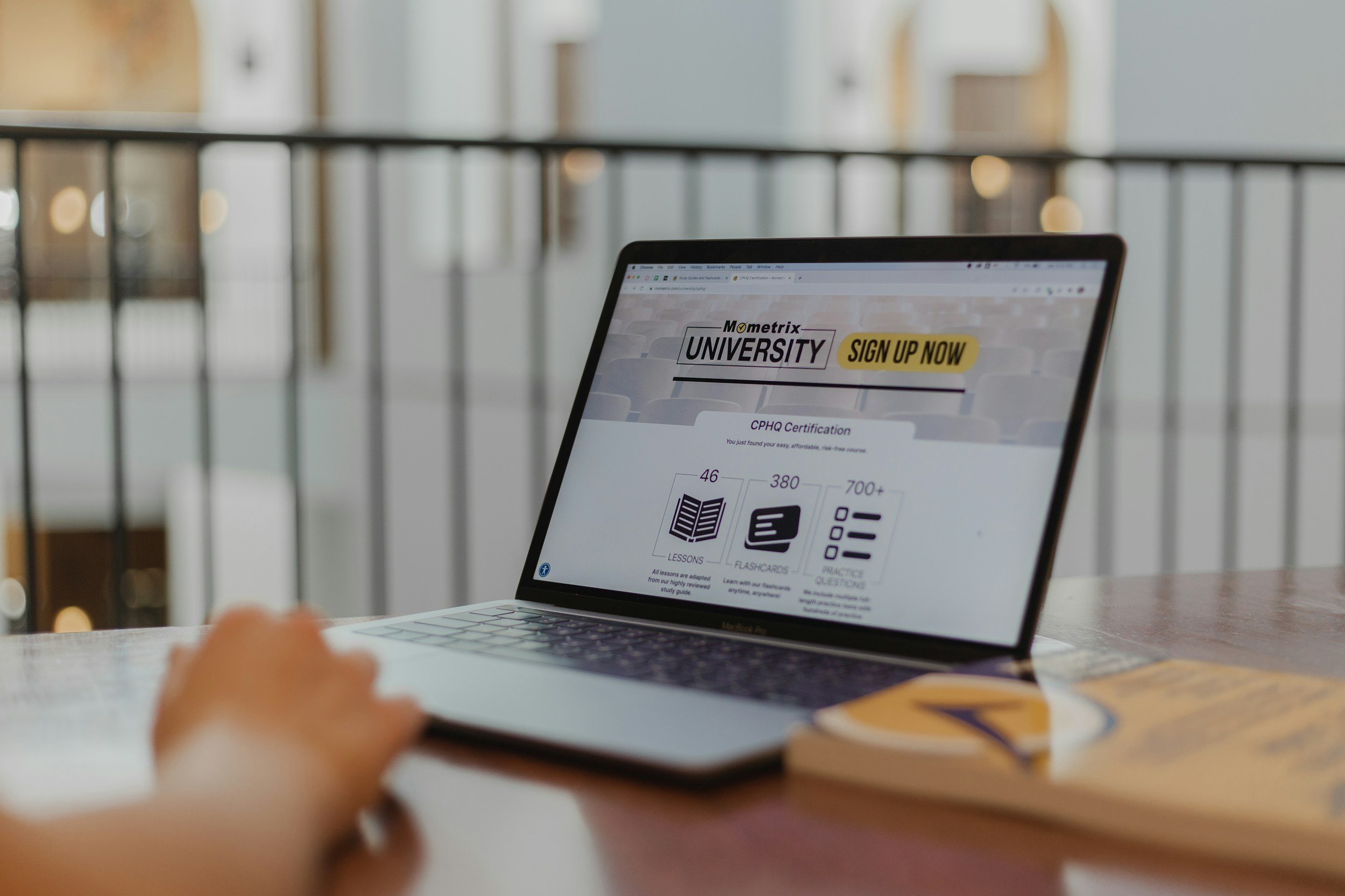 A person using a laptop on a table with a website for university sign-up displayed on the screen  | Compass Rose Student Housing