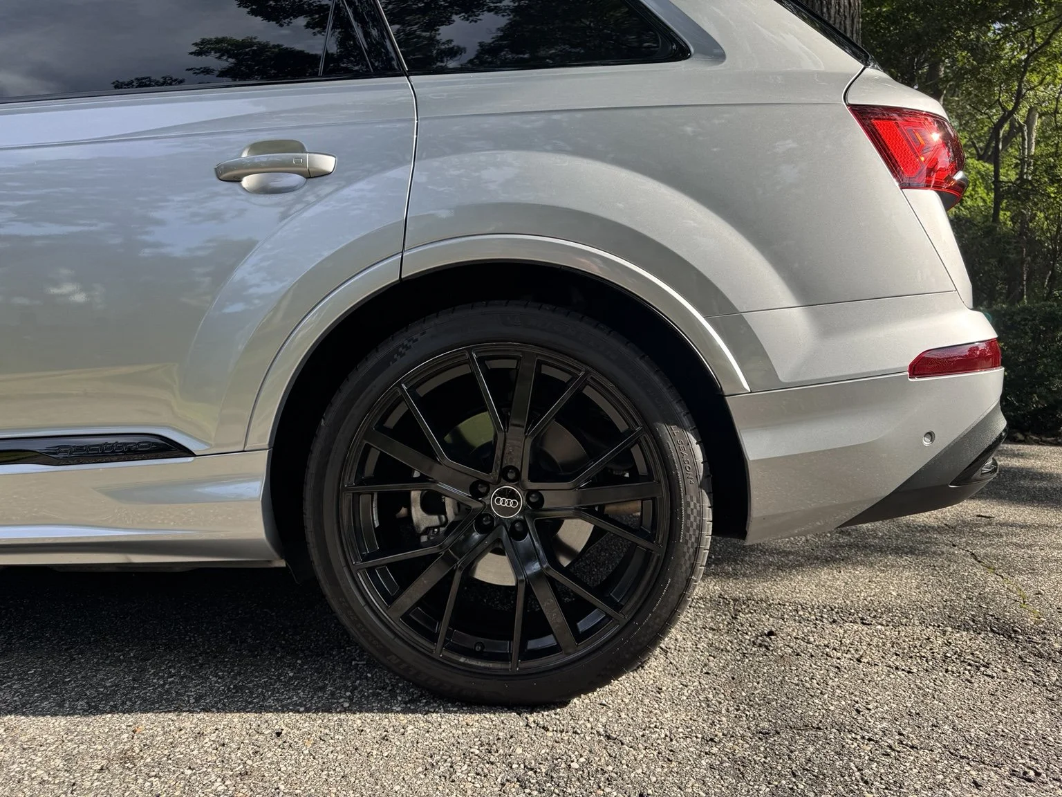 Close-up of a silver Audi Q7 rear wheel and exterior finish.