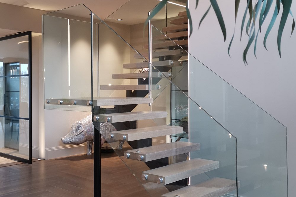 Modern floating staircase with glass railings in a contemporary home interior.