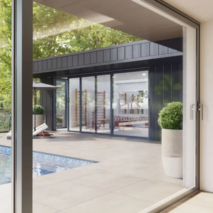 Modern backyard with swimming pool, outdoor lounge area, and large sliding glass doors leading to an indoor space.