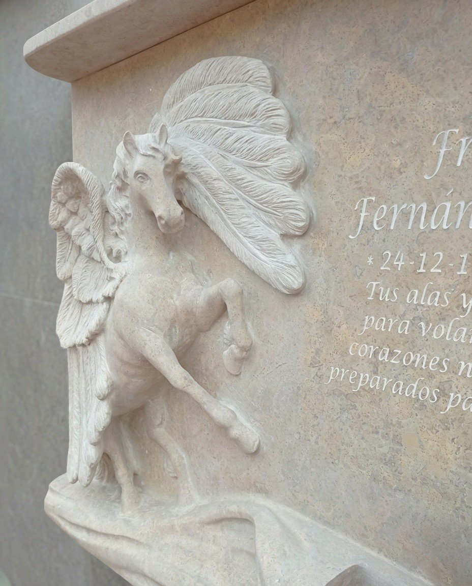 Detalle de Lápida esculpida a mano en mármol cenia con detalle de Pegaso jardinera de la misma pieza de alta calidad por el escultor Raúl Abad