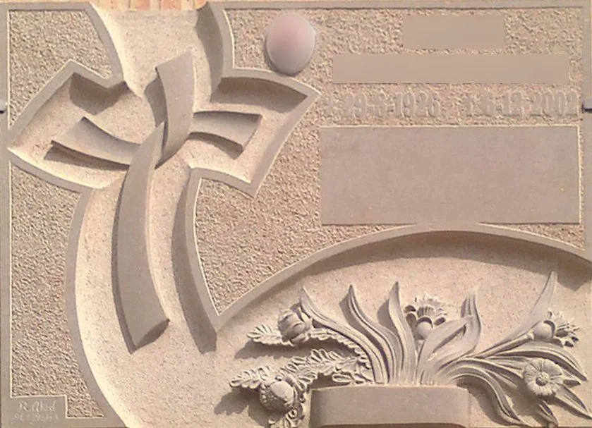 Lápida en mármol ulldecona con un diseño de cruz totalmente personalizado, esculpido directamente en la piedra junto con una jardinera integrada que incluye flores talladas en relieve. La pieza cuenta con un contorno personalizado y un cuidadoso cont