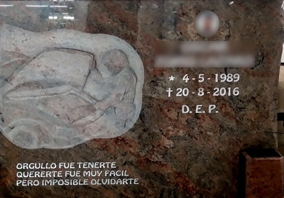 Lápida en granito rojo multicolor con un diseño personalizado y exclusivo dedicado al oficio de mecánico, acompañada de un búcaro sobrepuesto. Obra tallada a mano por el escultor Raúl Abad en nuestro taller de Alfara del Patriarca (Valencia).