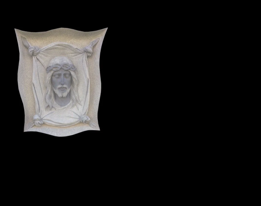 Lápida en granito negro con escultura en relieve de cabeza de Cristo y, en la parte posterior, diseño de la cabeza emergiendo de una sábana con cuatro nudos. Obra tallada a mano por el escultor Raúl Abad en nuestro taller de Alfara del Patriarca (Val