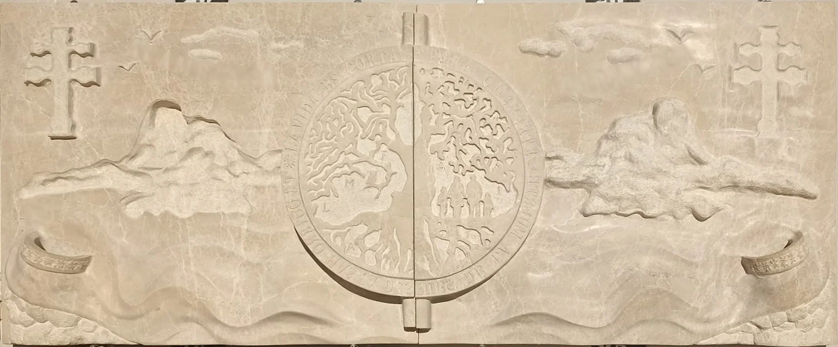 Conjunto de dos lápidas independientes esculpidas en noble mármol de Ulldecona, unidas por un simbolismo extraordinario y profundamente íntimo. El diseño representa el árbol de la vida junto a la familia y la cruz de Caravaca, incorporando además det