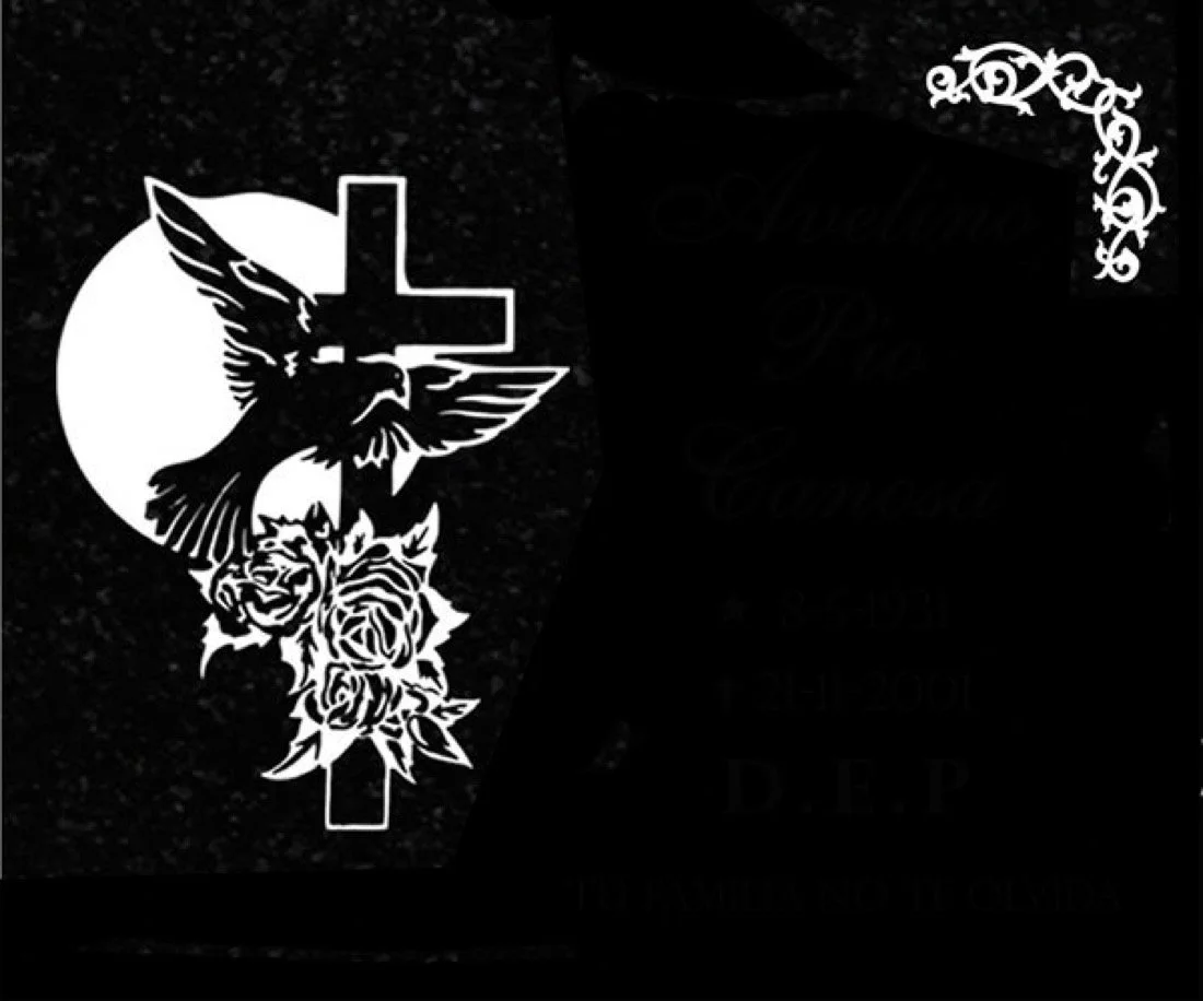 Lápida en granito negro grabada mediante la técnica de chorro de arena con un elegante diseño de cruz y motivos florales paloma y sol . Obra artesanal realizada con precisión por el escultor Raúl Abad en nuestro taller de Alfara del Patriarca (Valenc