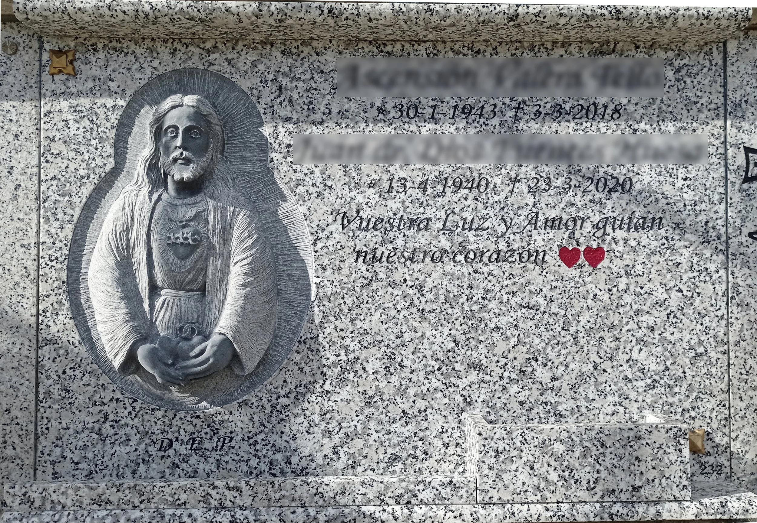 Lápida realizada en granito gris Quintana con una sofisticada incrustación de un bloque de granito negro. Sobre esta pieza combinada destaca una escultura tallada a mano e integrada con precisión en el diseño general. Una obra maestra de diseño y con