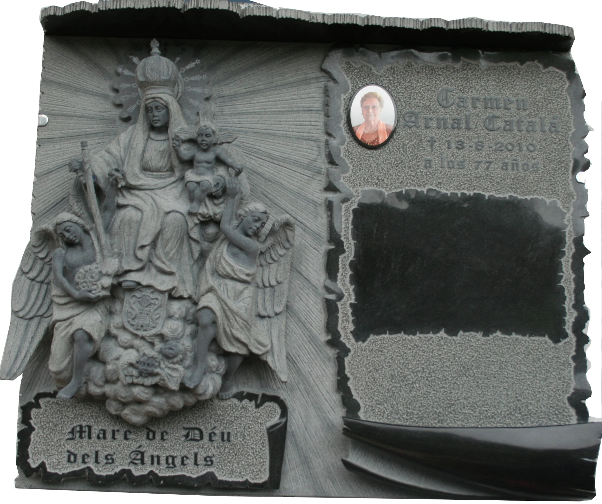 Lápida esculpida íntegramente en granito negro con un elaborado fondo rebajado, protagonizada por la Virgen de los Ángeles tallada en relieve. Destaca por el detalle de un pergamino central que acoge la inscripción en relieve, dejando espacio previst