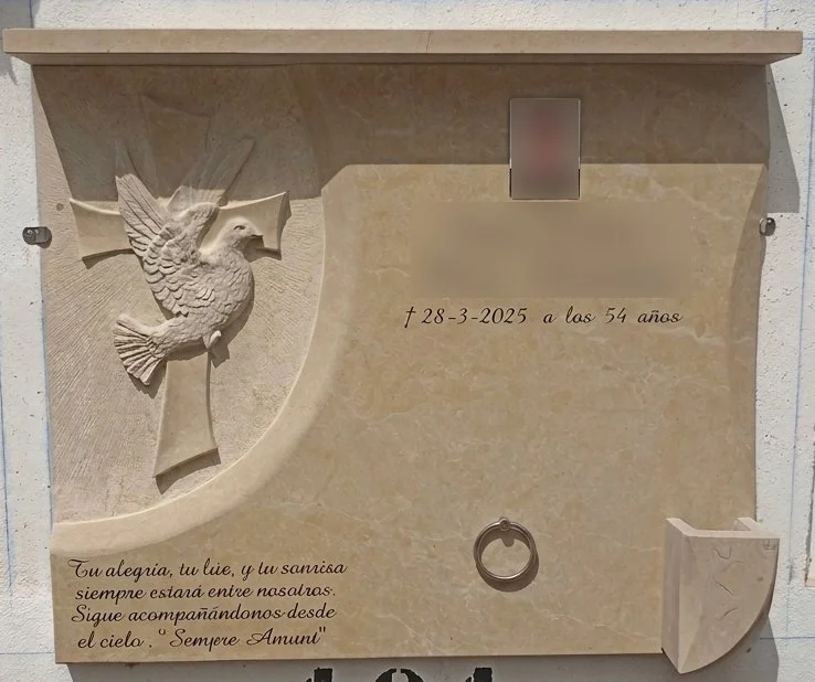 Lápida en mármol de Ulldecona con cruz pulida tallada y una delicada escultura de una paloma en acabado mate esculpida en el centro. El diseño se completa con elegantes biseles laterales, anilla y búcaro para flores. Trabajo de arte funerario persona