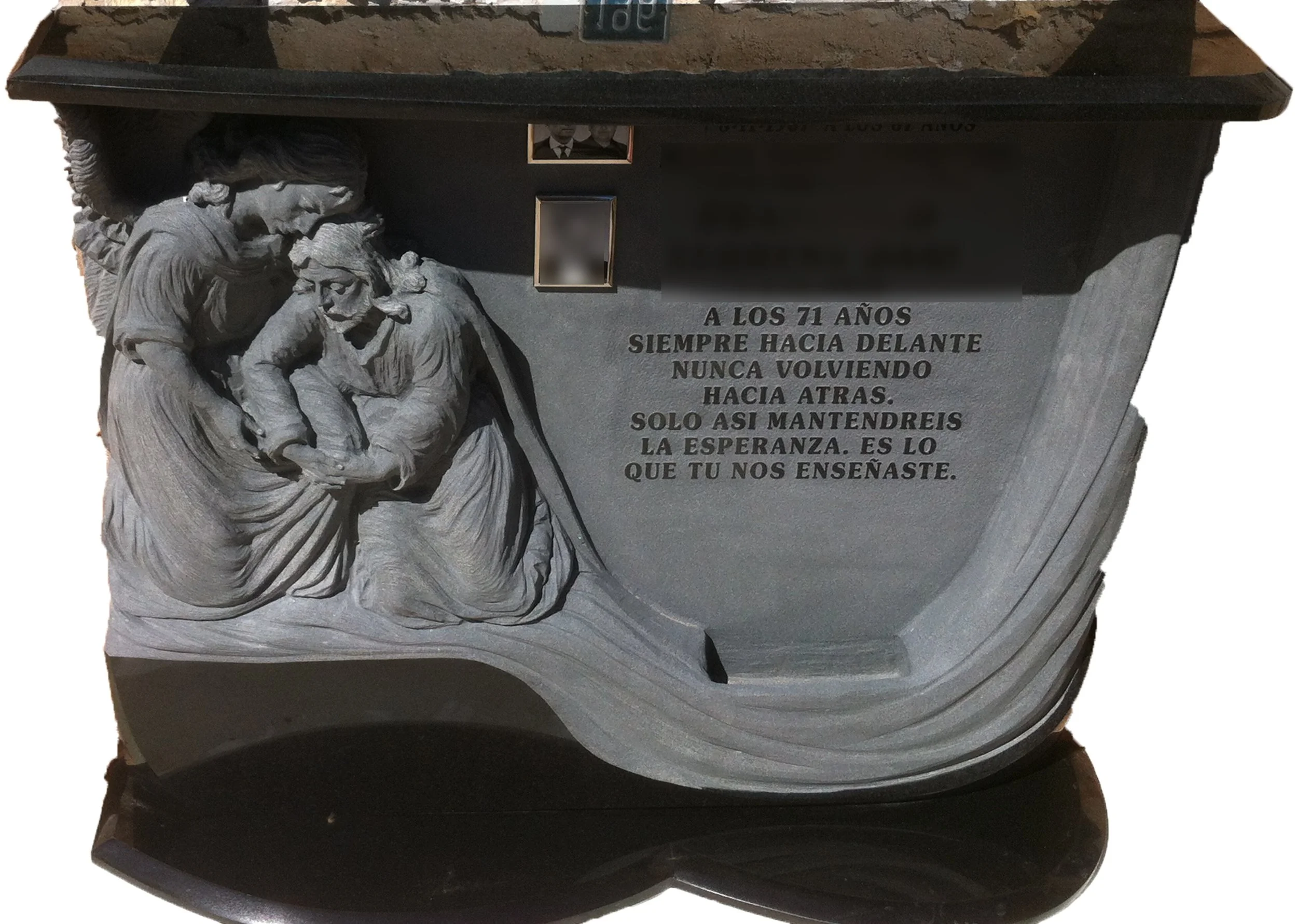 Escultura funeraria tallada artesanalmente en granito negro, que combina con elegancia acabados en mate y brillo. La obra está protagonizada por 2 figuras en alto relieve envueltas por un delicado motivo de cortinaje esculpido de forma que la propia 