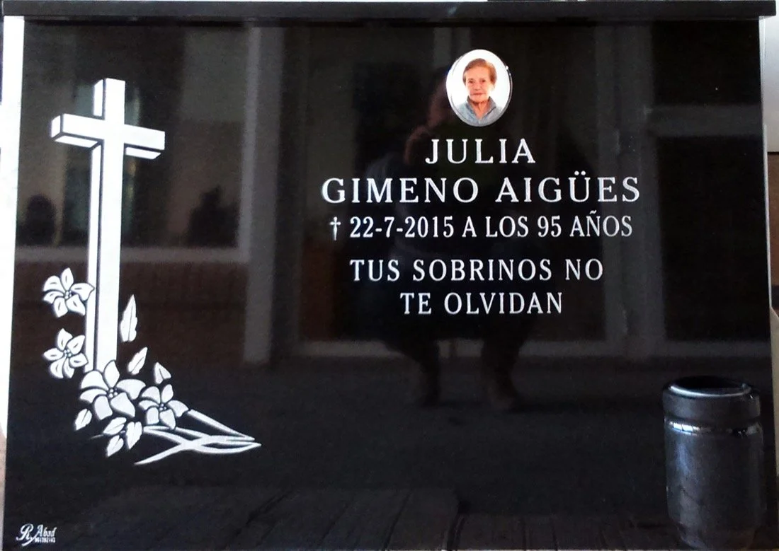 Lápida grabada mediante la técnica de chorro de arena con elegante diseño de cruz y motivos florales y bucaro. Obra artesanal realizada con precisión por el escultor Raúl Abad en nuestro taller de Alfara del Patriarca (Valencia).