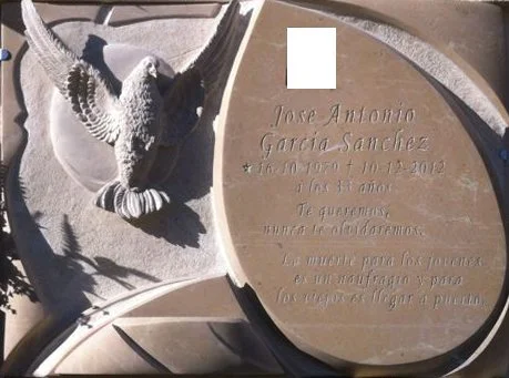 Lápida en mármol Cenia de diseño único, que combina magistralmente superficies pulidas y mates —como la paloma esculpida—, acompañada de una inscripción grabada, foto cerámica incrustada y jardinera integrada en la misma pieza. Una escultura funerari