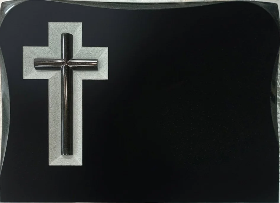 Lápida en granito negro con cruz redonda tallada y fondo repicado artesanalmente. Cuenta con un elegante acabado en biseles tanto en los laterales como en la parte superior, destacando la maestría del arte funerario elaborado en nuestro taller de Alf