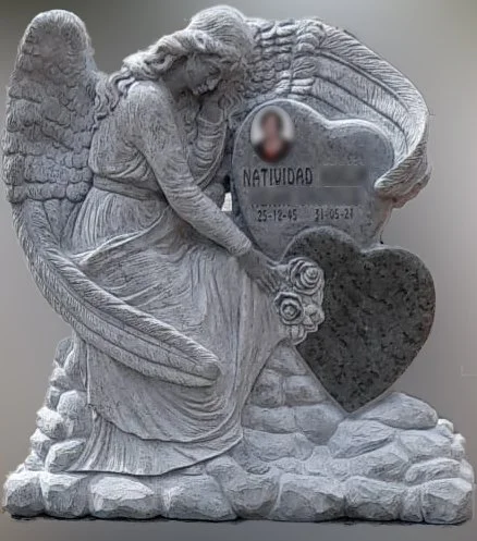 Espectacular panteón escultórico tallado en un imponente bloque de piedra verde, presidido por una magistral figura de ángel en relieve que se erige con naturalidad sobre un basamento de rocas esculpidas. La imponente escultura despliega sus grandes 