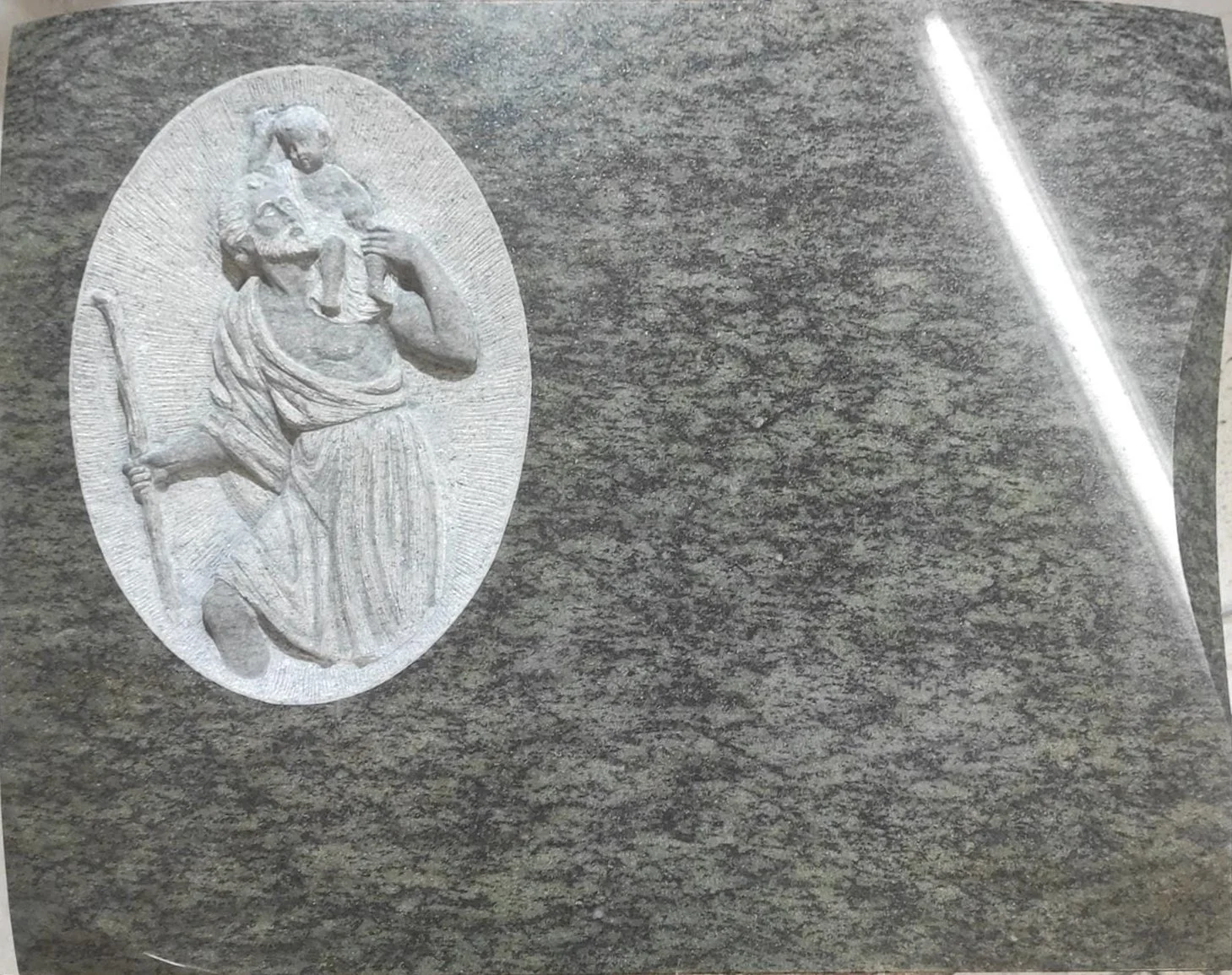 Lápida en granito con una hermosa escultura de San José tallada a mano y destacada sobre un cuidado fondo repicado artesanalmente. Una pieza de arte funerario de gran solemnidad y calidad, elaborada en nuestro taller de Alfara del Patriarca, Valencia