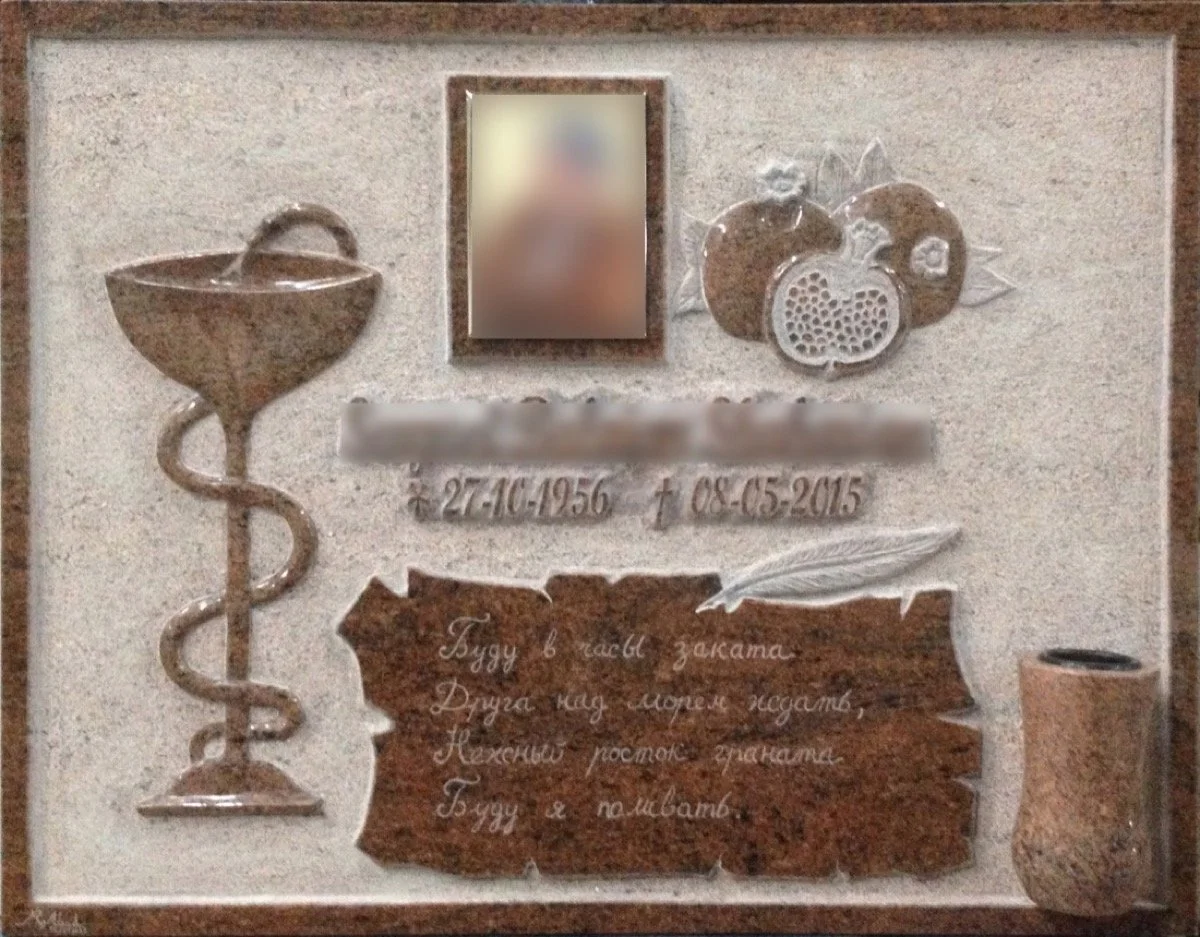 Lápida esculpida artesanalmente en granito rojo multicolor, diseñada con profundos detalles personales que rinden homenaje a la vida y profesión del difunto, incluyendo la representación  de las granadas de su tierra natal. Destaca por una inscripció