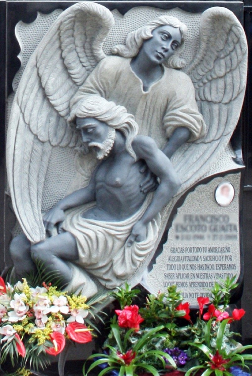 Espectacular lápida doble de gran envergadura y notable grosor, que destaca por su imponente relieve representando a Cristo junto a un ángel de alas minuciosamente talladas. Una obra monumental que requirió meses de trabajo artesanal, combinando supe