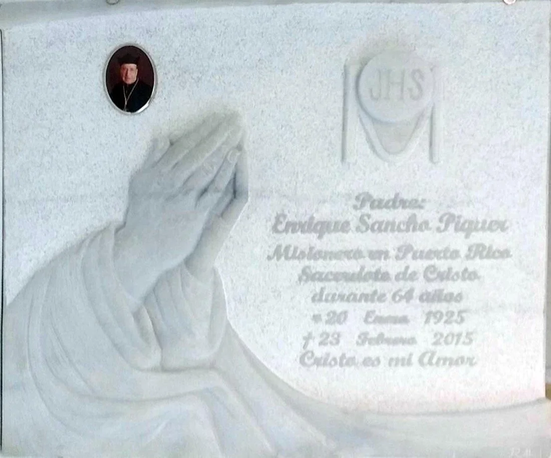 Lápida en mármol blanco Macael con superficie rebajada y escultura en relieve de manos con hábito religioso, diseñada en honor a un miembro de una orden religiosa. Obra artesanal realizada por el escultor Raúl Abad en nuestro taller de Alfara del Pat