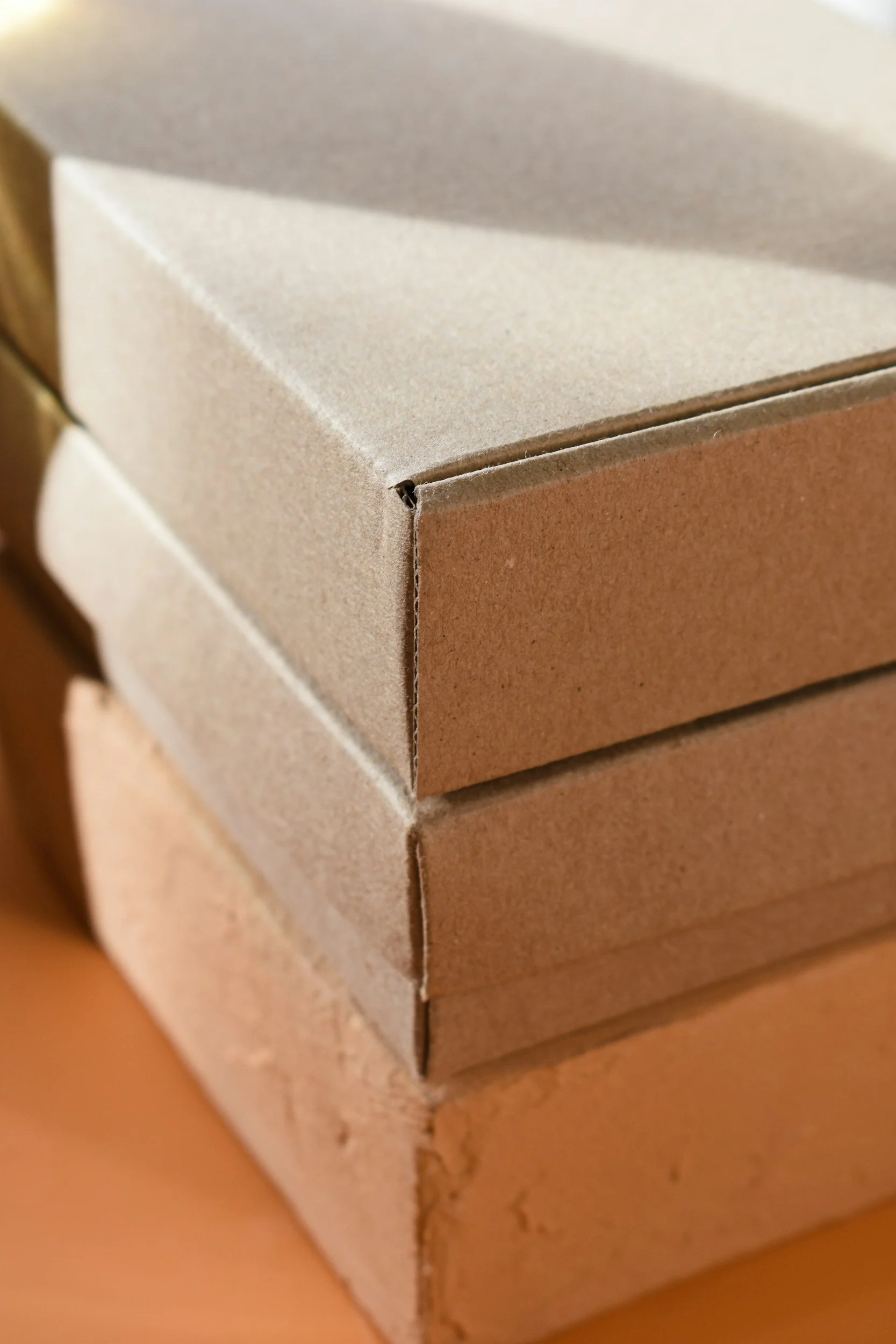 Close-up of stacked cardboard boxes, showing edges and surface textures.