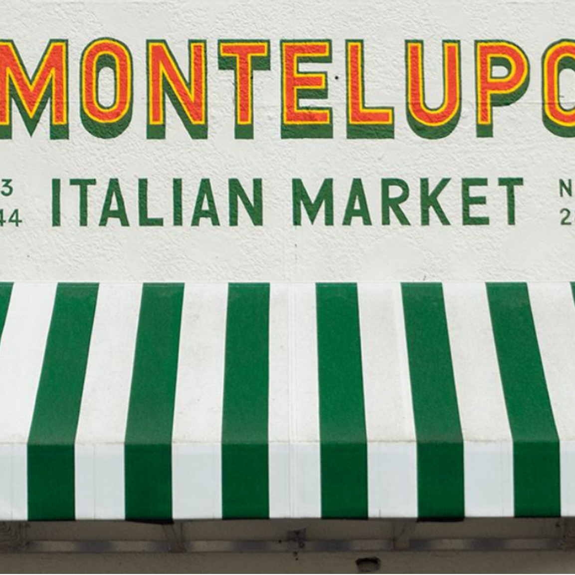 Sign for MonteLupo Italian Market with green and white striped awning.