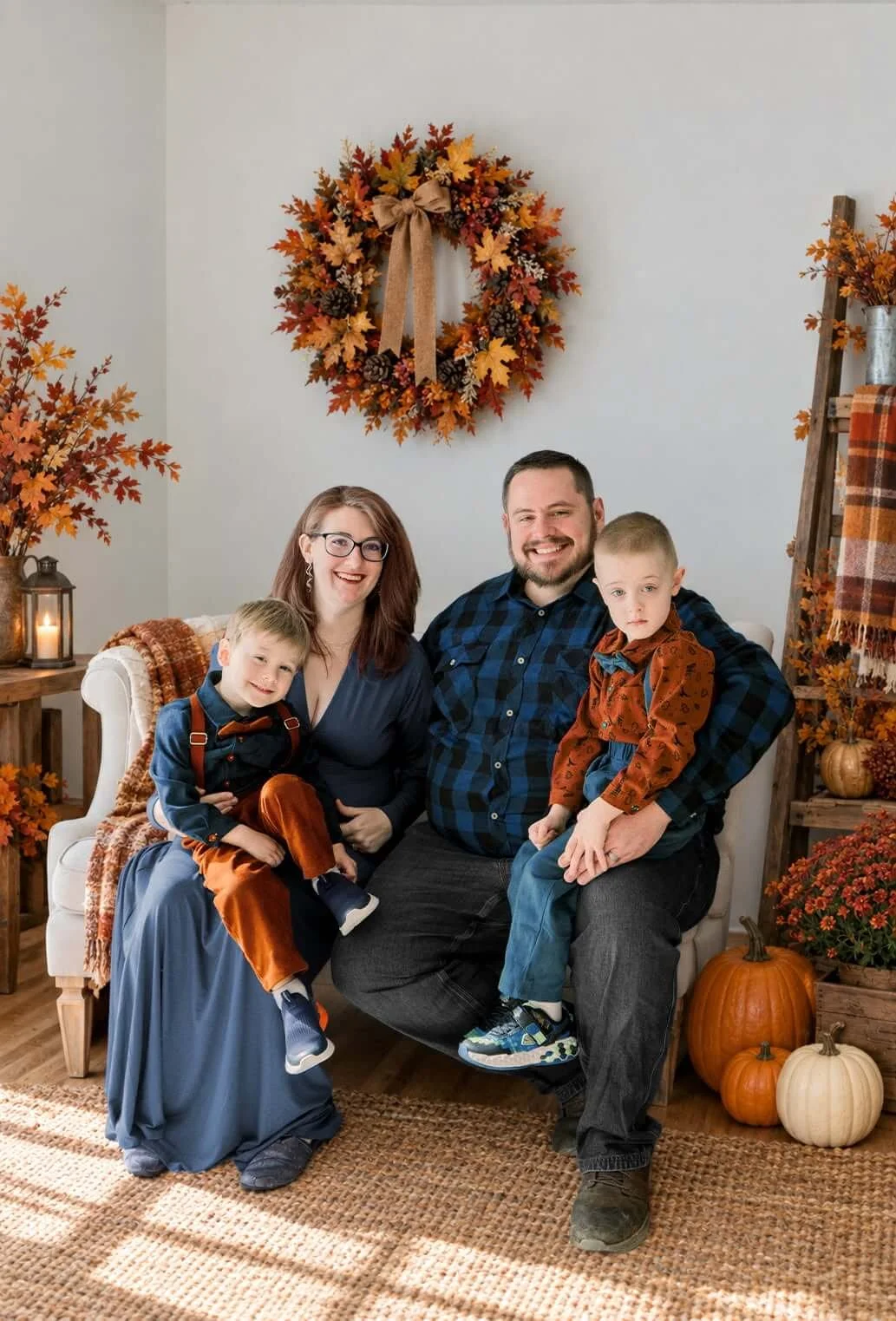 family of five sitting on a couch with fall pumpkin decor