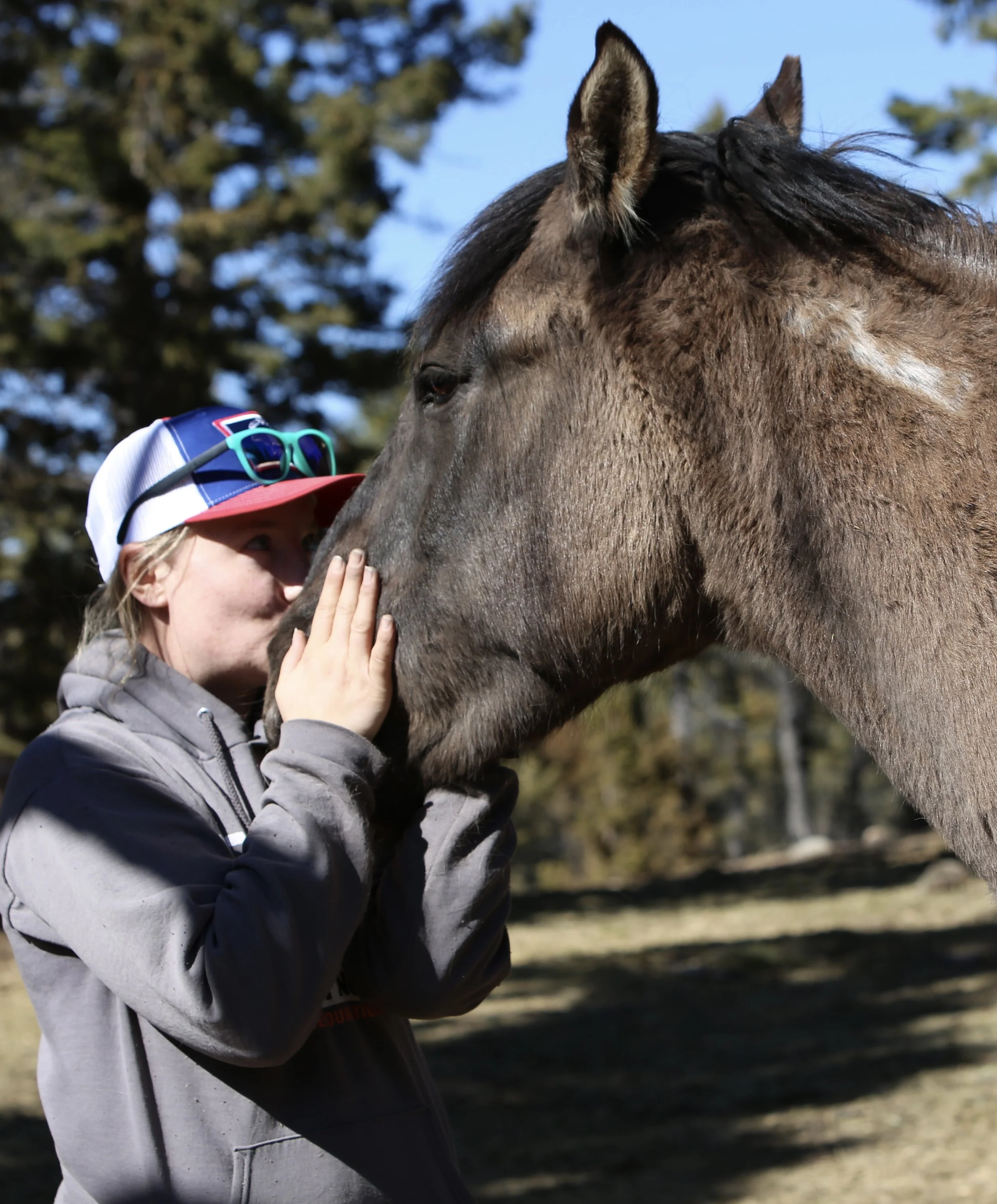 Photo taken by Ashley Mancuso of Lisanne kissing mustang Pistachio on the nose.