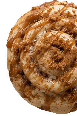 A close-up of a donut topped with caramel drizzle and crumbly streusel.