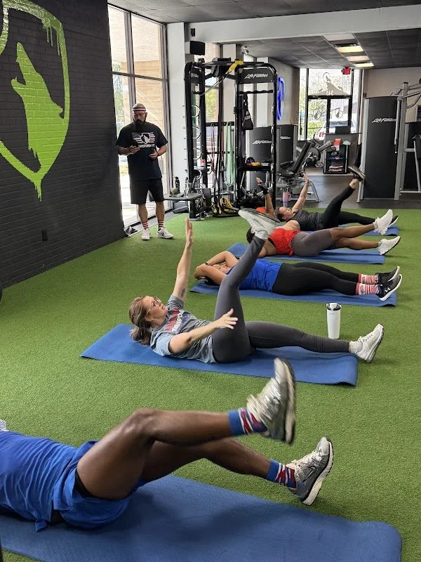 Small group training session with a trainer guiding the exercises in a circuit.