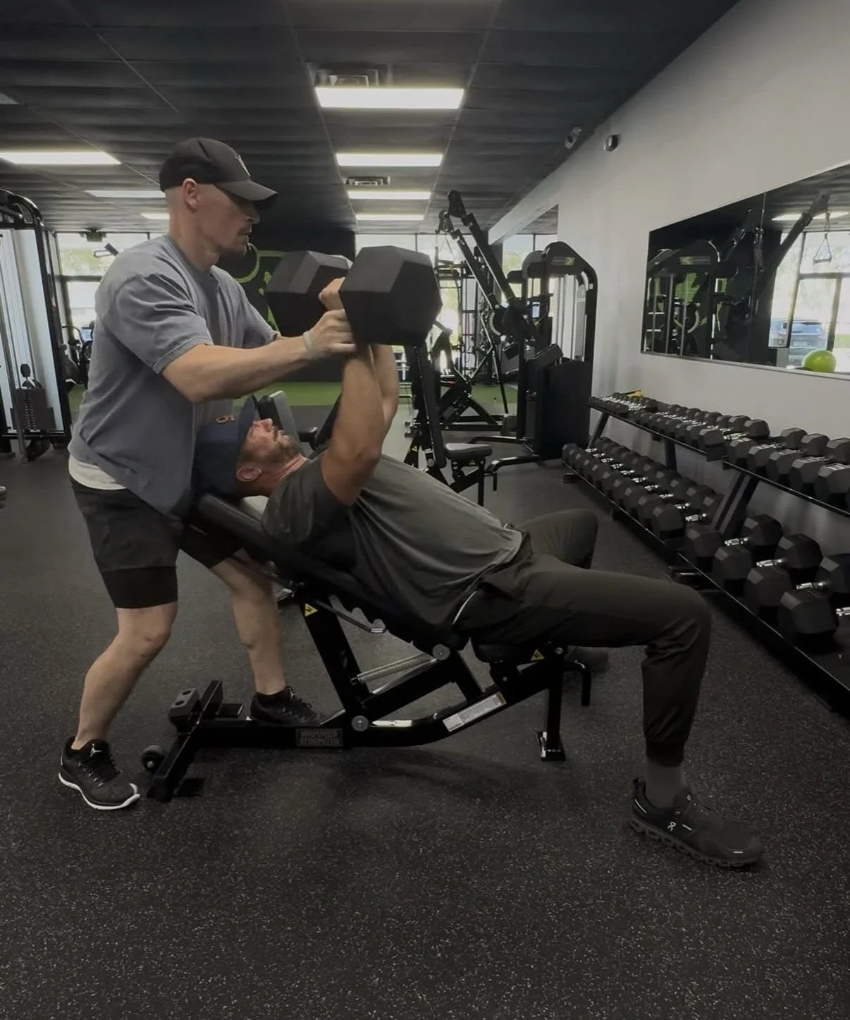 Personal Training spotting a client while lifting weights.