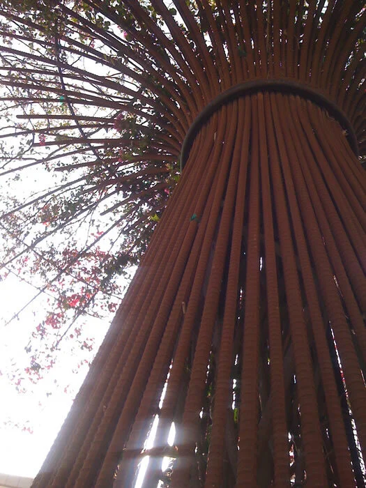 Closeup of a “tree” made of rebar that had viney plants growing through it