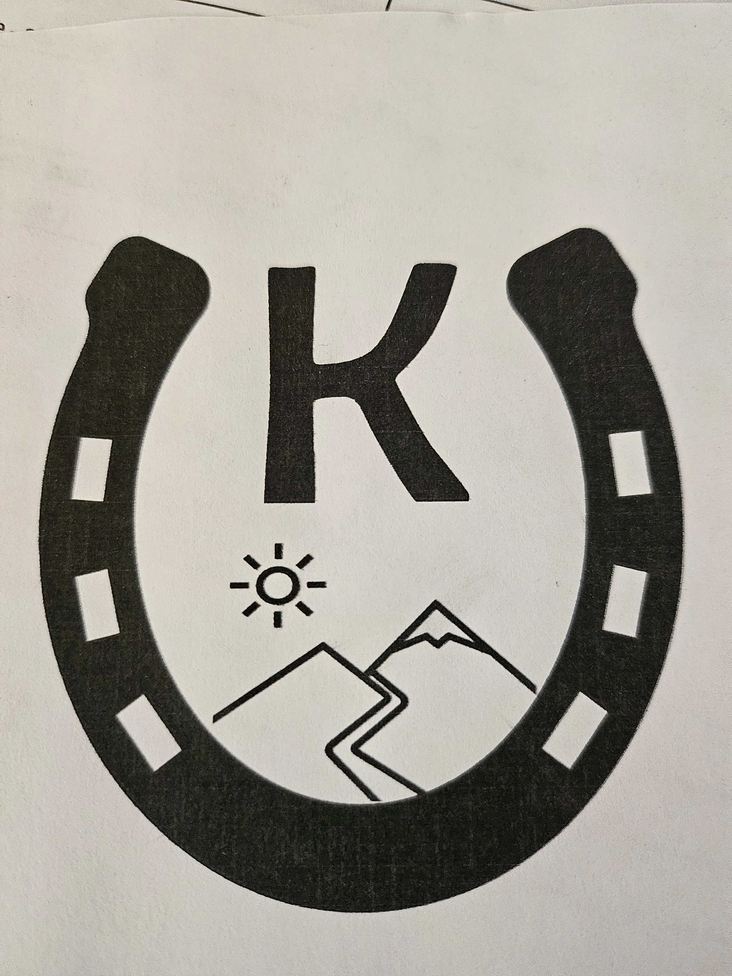 Black and white circular icon featuring mountains, a sun, and a mountain scene