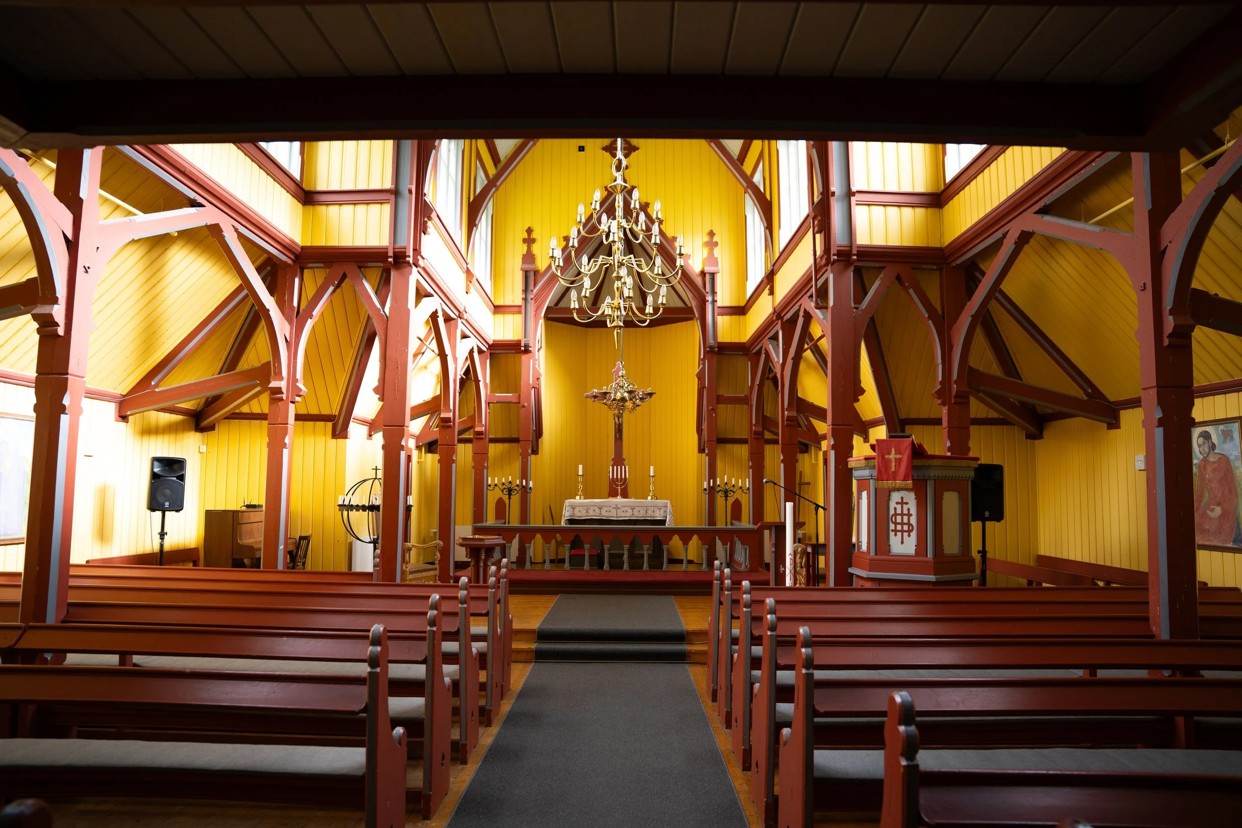 Innenraum einer Holzkirche mit Altar und Kirchenbänken – Architekturfotografie